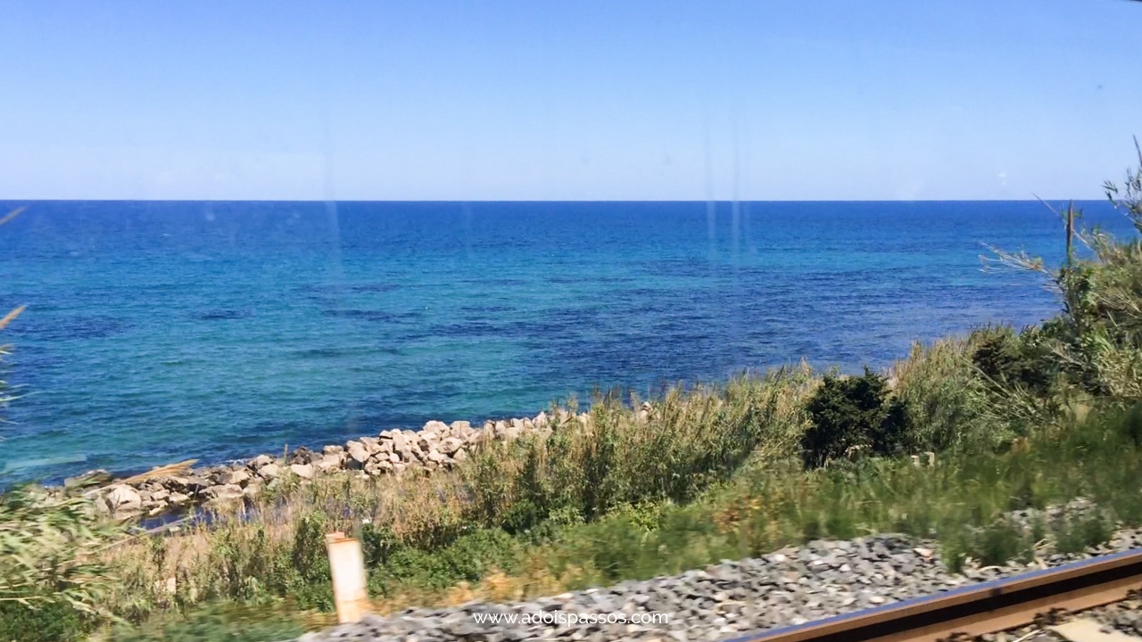 Mar visto da janela do trem em viagem pela Sicília.